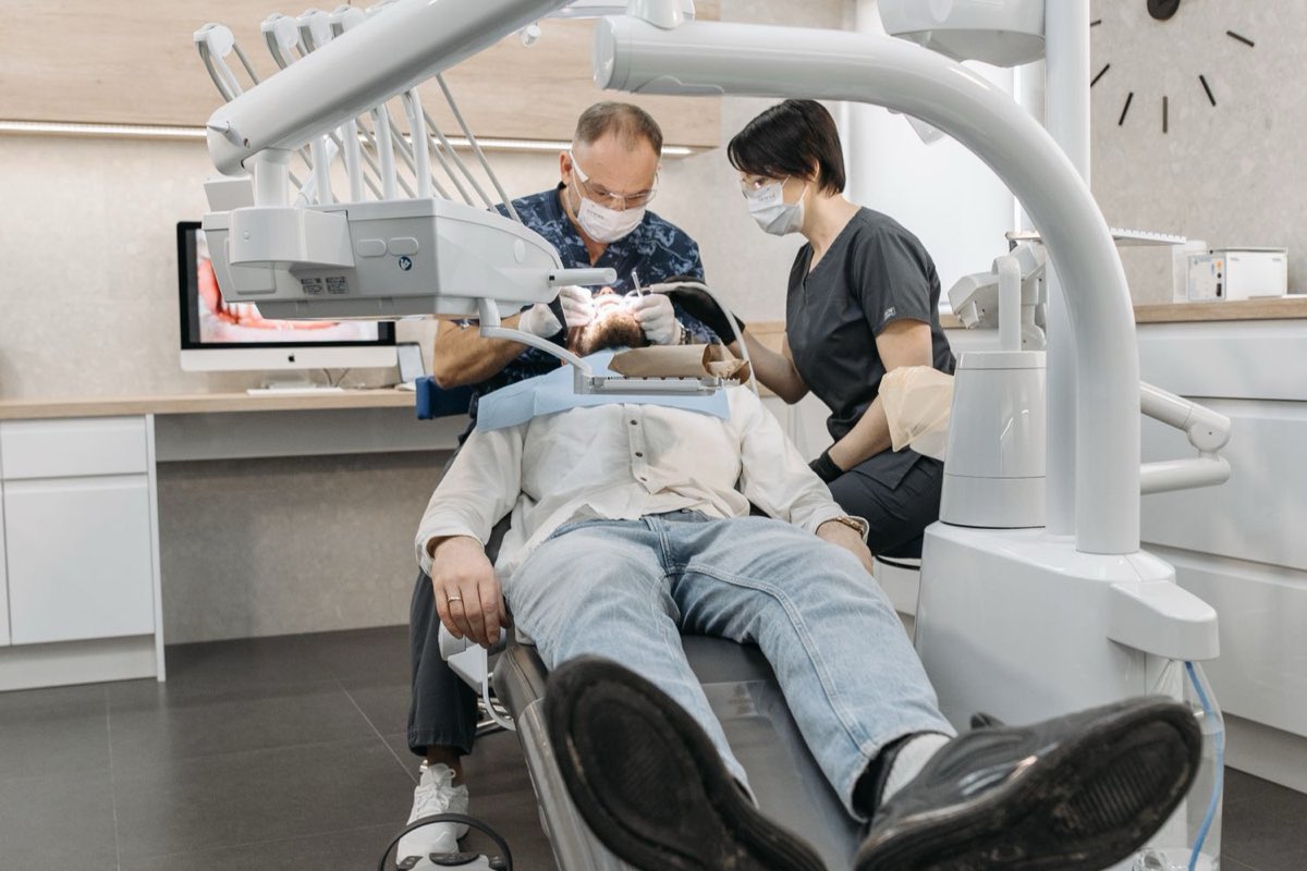 A dentist and assistant treating a patient in a clinic